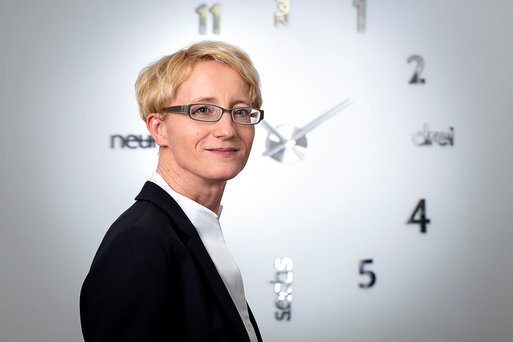 Rechtsanwältin Susanne Höpfner vor Wanduhr